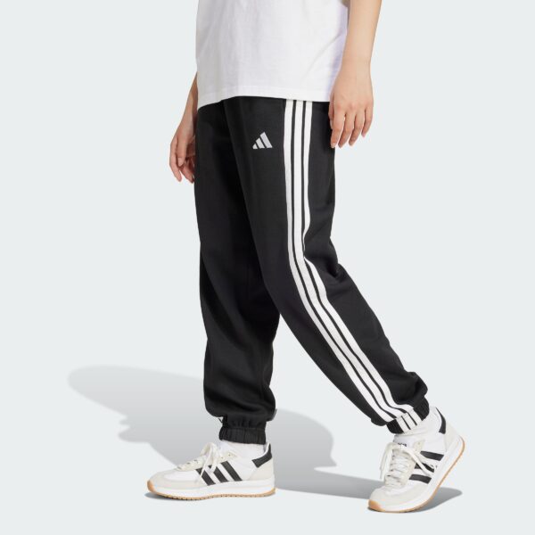 JE1276_000_plp_model.jpgJE1276_000_plp_model.jpg Pantalones holgados de vellón de 3 bandas Adidas Essentials para mujer-
